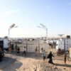 People Walk At The Gate Of A Makeshift Camp For Displaced People Near Aden