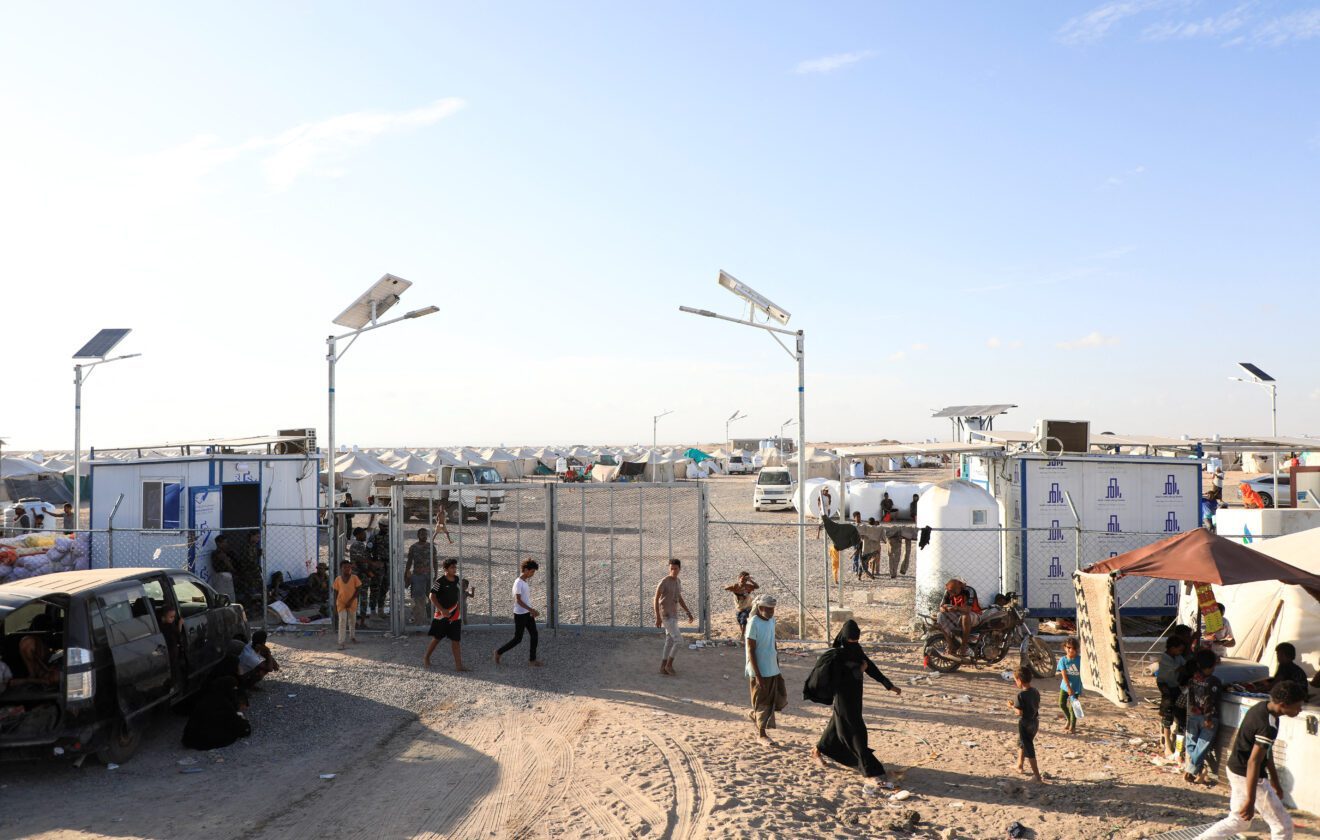 Houthi Missiles Hit Yemen's Presidential Palace as Saudi Air Defenses Struggle to Stop Attacks 1 People Walk At The Gate Of A Makeshift Camp For Displaced People Near Aden