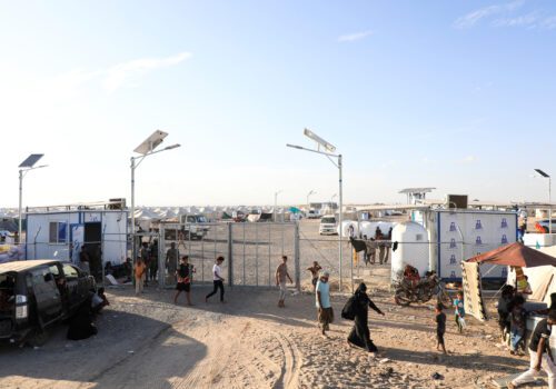 People Walk At The Gate Of A Makeshift Camp For Displaced People Near Aden